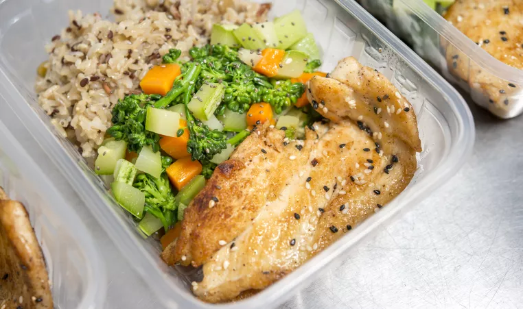 a photo of chicken, rice and vegetables in a container