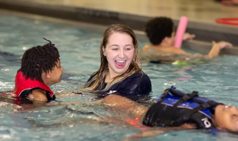 a swim instructor with two kids for swim lessons