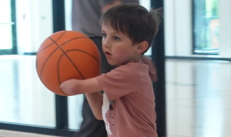 a young member playing basketball 