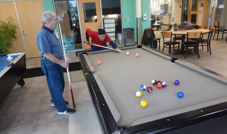 two gentlemen play billiards at the westside family ymca