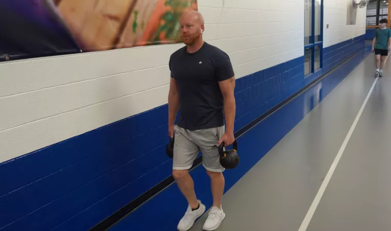 Corning Family YMCA member carrying kettlebell