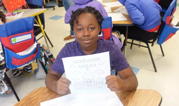 Ten-year-old Shyheim poses holding a drawing of Sacrè-Coeur Basilica in the Power Scholars Academy.