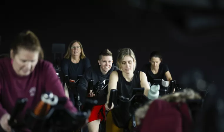 group of ymca members partake in cycle class, smiling