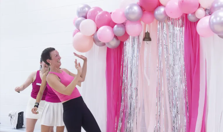 Cathleen Bush rings the4 bell with pink decorations around