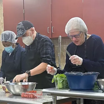 a group of foodlink volunteers cooking in the lily cafe