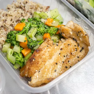 a photo of chicken, rice and vegetables in a container