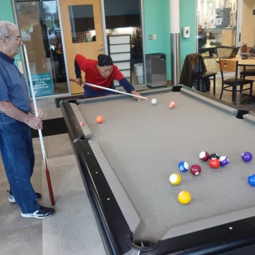 two gentlemen play billiards at the westside family ymca