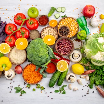 top view of fres foods, spices and vegetables on a white cooking table