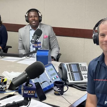 Pam Cowan, Chief Experience Officer, and Ernie Lamour, President & CEO, smile with Evan Dawson, host of Connections of WXXI News during a recent conversation for the show
