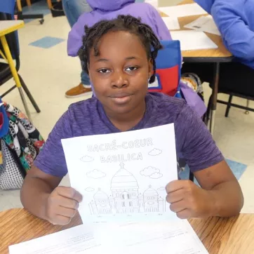 Ten-year-old Shyheim poses holding a drawing of Sacrè-Coeur Basilica in the Power Scholars Academy.