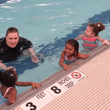 lifeguard teaching kids in the pool