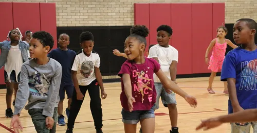 a group of kids dancing in a gym