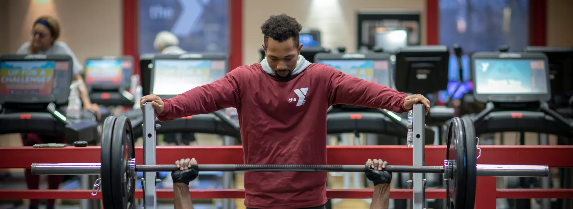 a ymca staff member spotting a member as they bench press at the maplewood family ymca