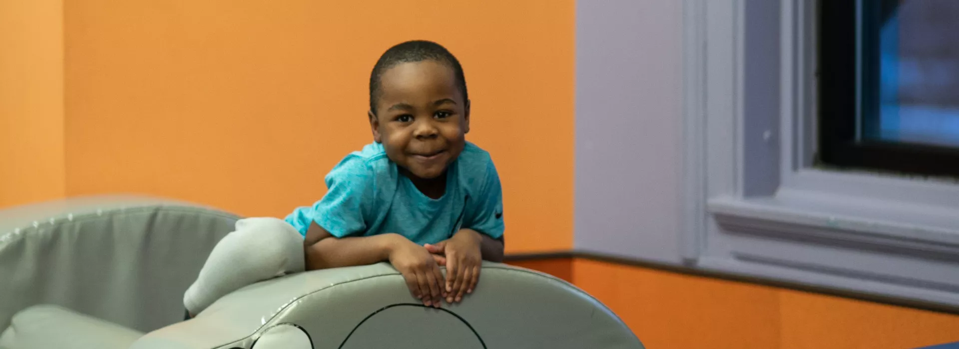 a small child on a foam elephant slide at the maplewood family ymca child care center