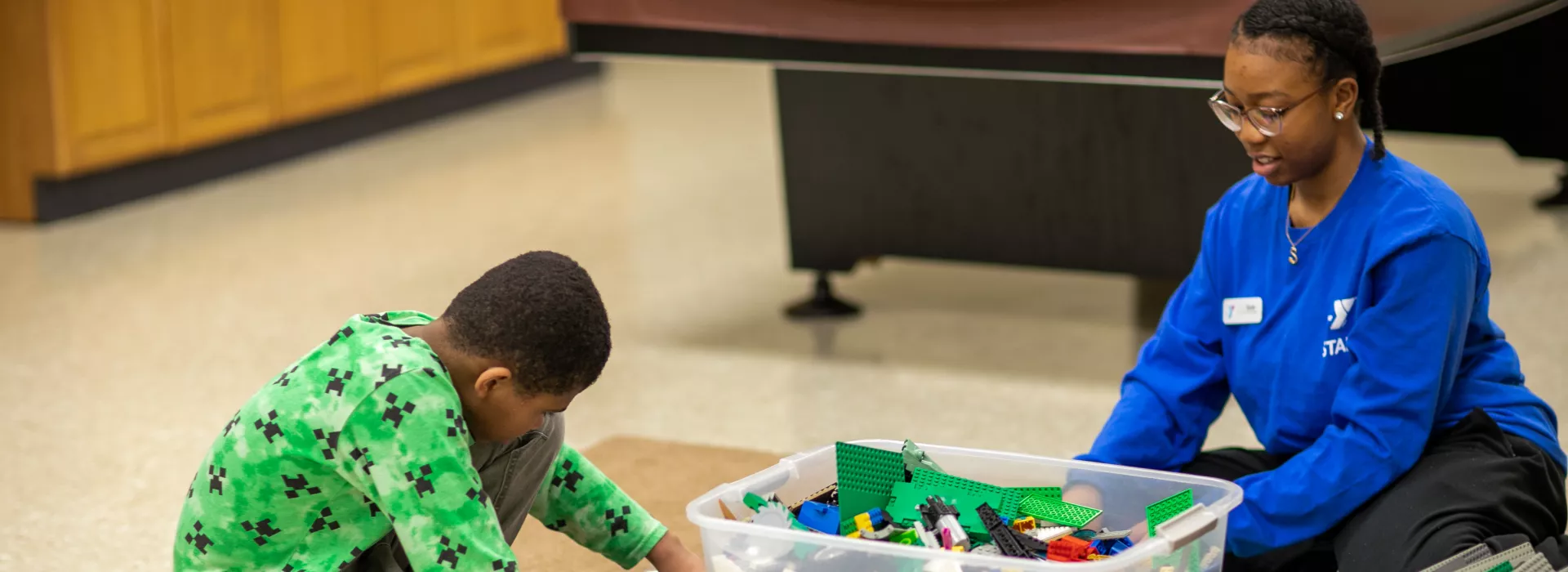 staff member and child playing with legos