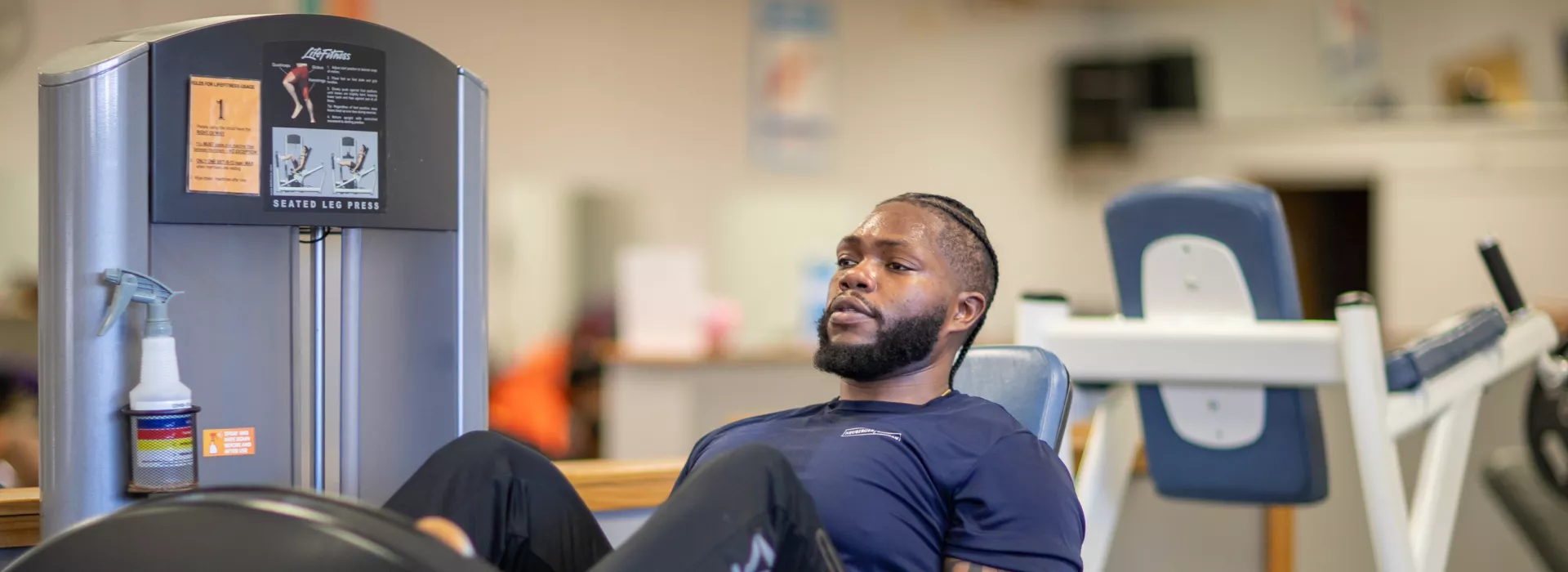 man exercising on a leg press machine at the thurston road ymca neighborhood center