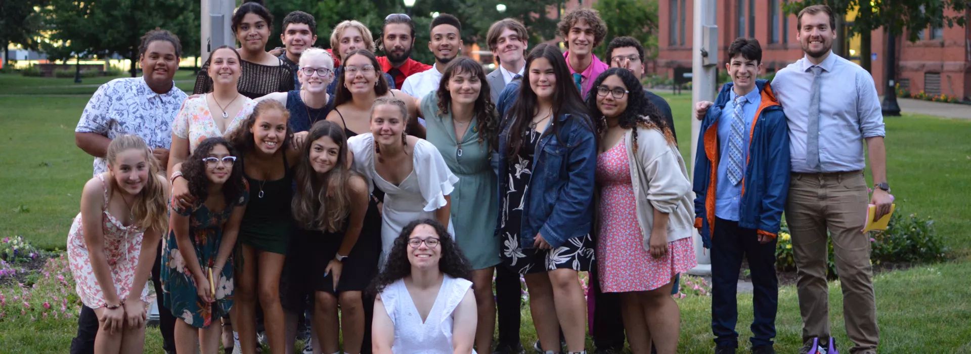 A large group of teens and a YMCA Staff Member smiling at the camera