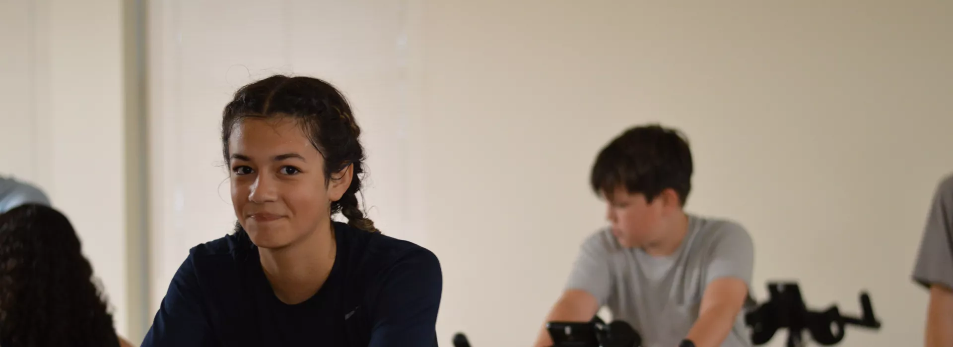 two teens on stationary bikes
