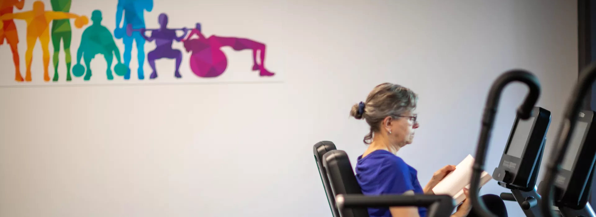 a woman reading on a recumbent bike