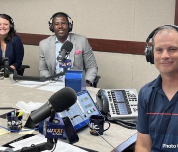 Pam Cowan, Chief Experience Officer, and Ernie Lamour, President & CEO, smile with Evan Dawson, host of Connections of WXXI News during a recent conversation for the show