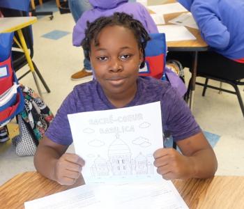 Ten-year-old Shyheim poses holding a drawing of Sacrè-Coeur Basilica in the Power Scholars Academy.