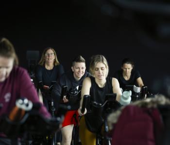 group of ymca members partake in cycle class, smiling