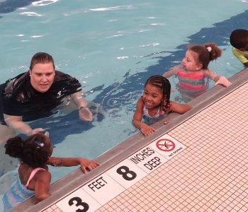 lifeguard teaching kids in the pool
