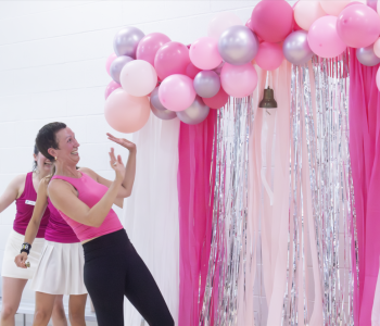 Cathleen Bush rings the4 bell with pink decorations around